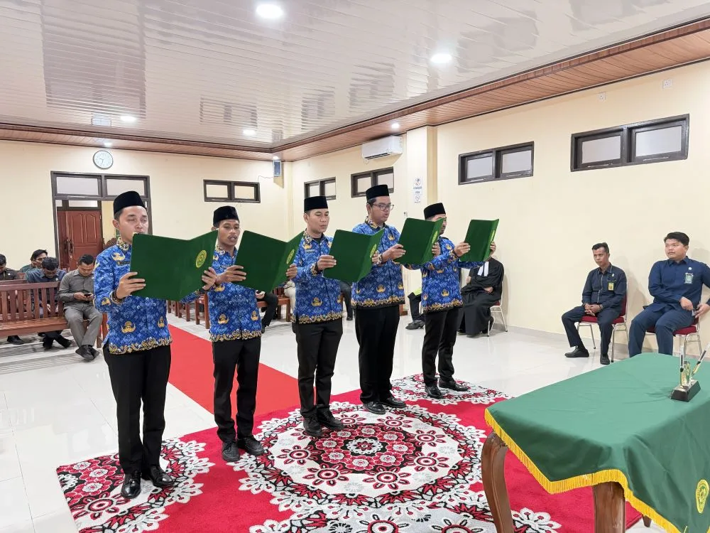 Pegawai yang disumpah berdiri mengucapkan sumpah jabatan didampingi rohaniwan